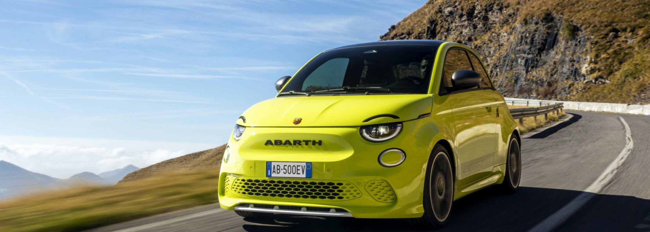 Gelber Abarth 500e auf einer Bergstrasse fahrend